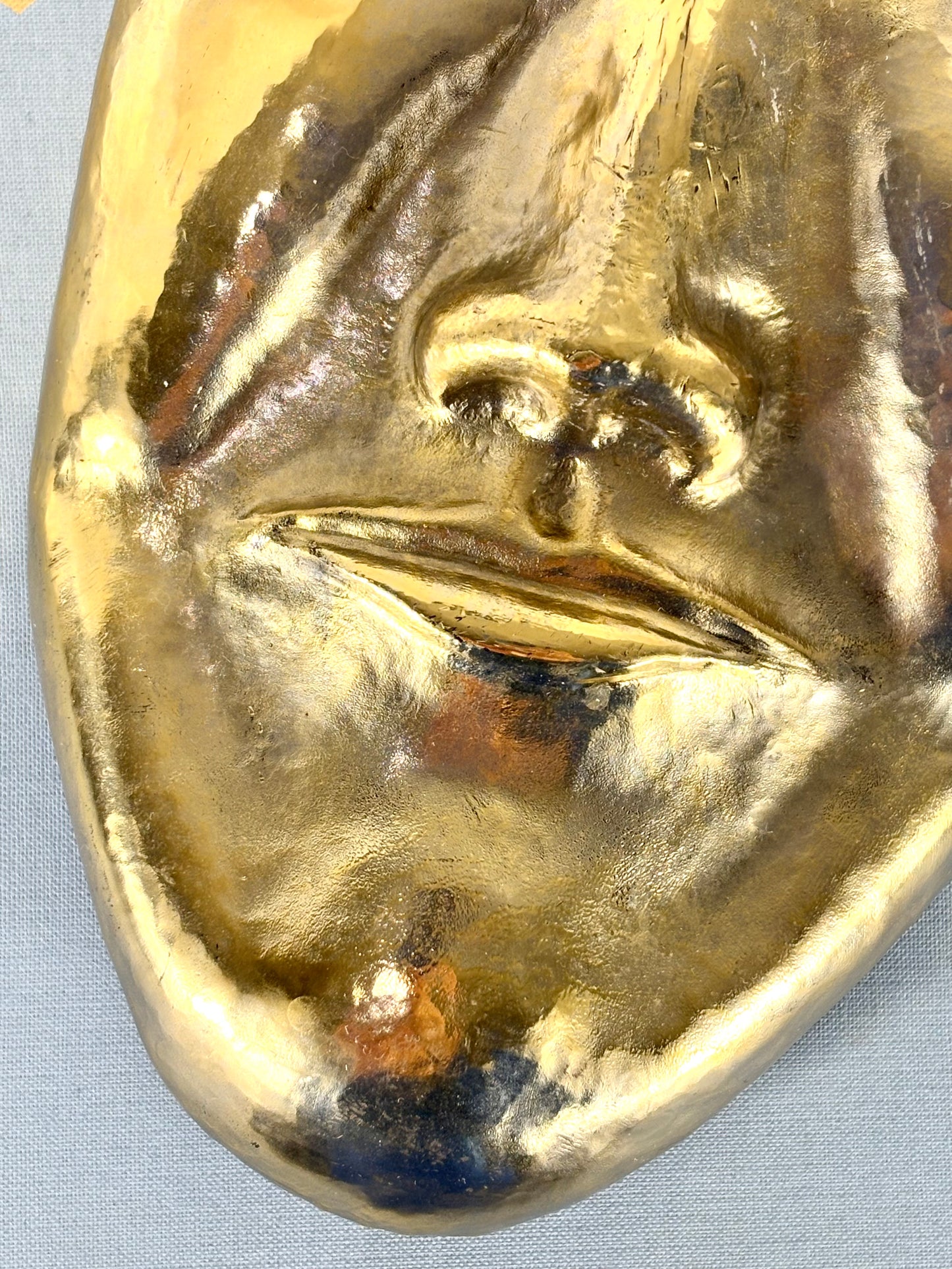 Abstrakte handgefertigte Aluminium Maske in gold mit Wandaufhängung